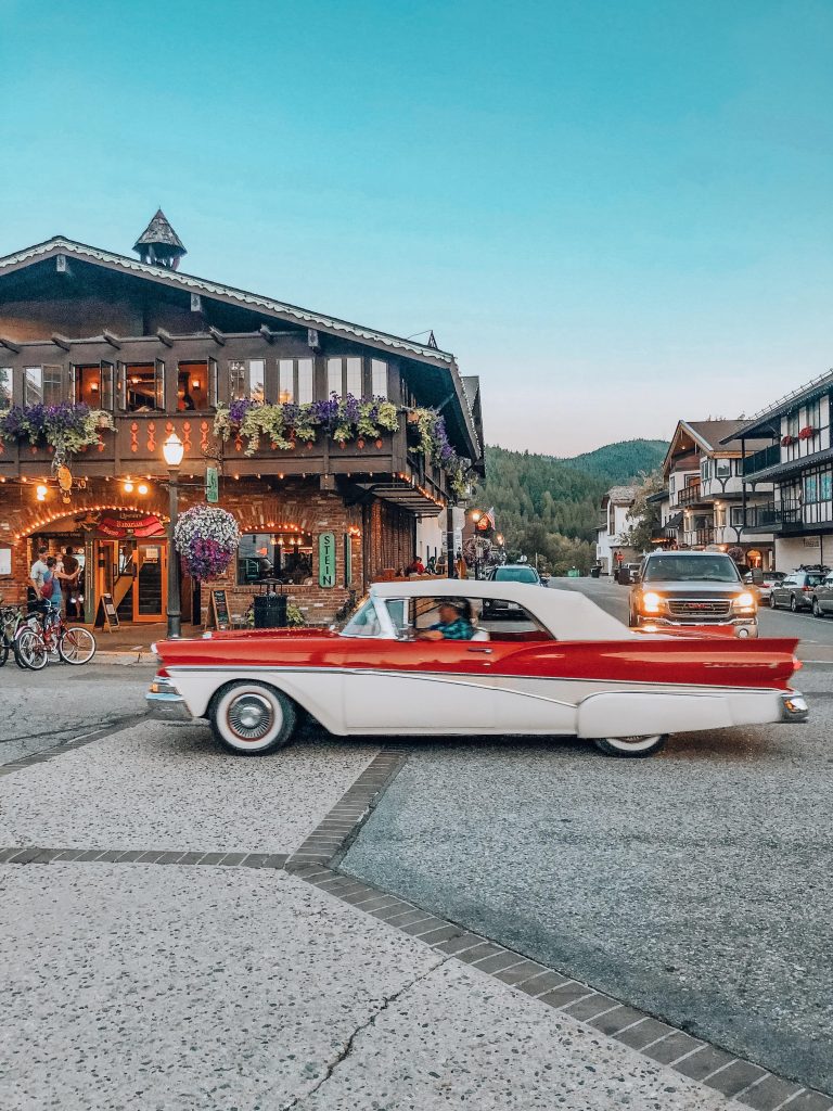 outside view of Stein brewery in leavenworth washington with vintage white and red old car driving by