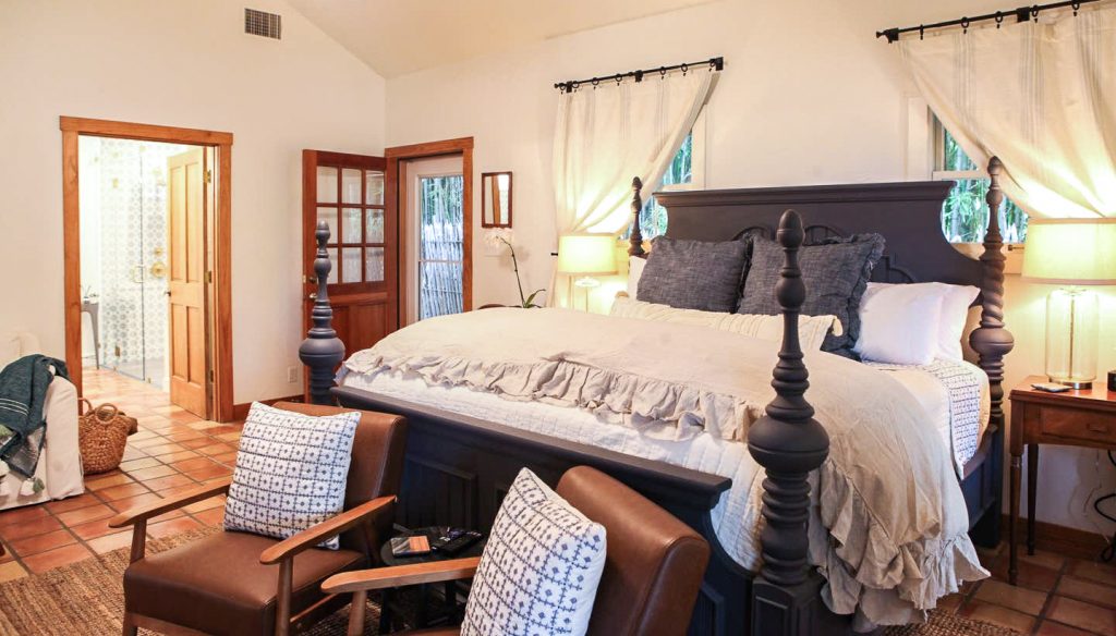 master bedroom with king size bed and decor in emma haus fredericksburg luxury vacation rental, airbnb rental in fredericksburg tx, charming rental in texas hill country